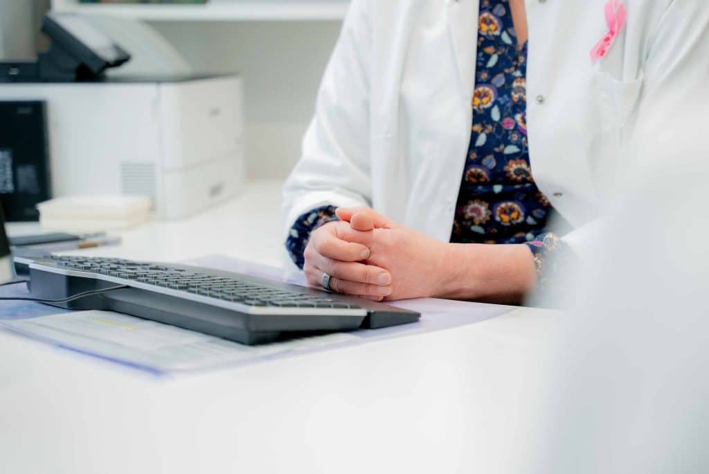 Syöpälääkäri vastaanotolla Lääkärikeskus Gynekossa Oulussa kuuntelee potilasta ja suunnittelee yksilöllistä hoitoa.